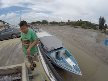 Full length of boy on boat against sky