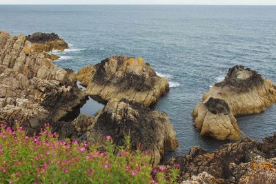 Scenic view of rocks in sea against sky