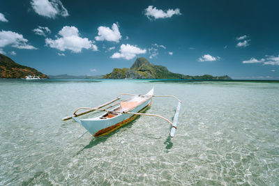 Boat moored in sea against sky