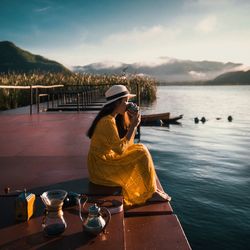 Woman in sea by mountains against sky