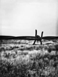 Low angle view of silhouette fence on field against sky