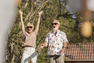 Man wearing sunglasses standing against plants