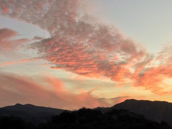 Low angle view of silhouette mountains against dramatic sky