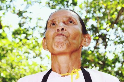 Low angle portrait of man against tree