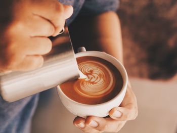 Close-up of hand holding coffee cup