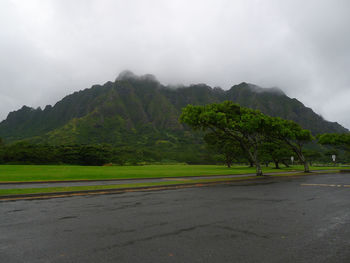 Road by mountains against sky