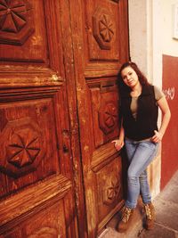 Portrait of woman standing against closed door