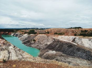 Aerial view of dam on rock against sky