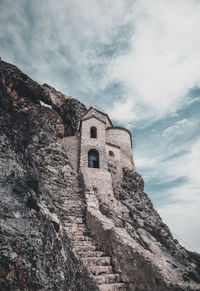 Low angle view of old building against cloudy sky