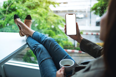 Cropped hands of woman using mobile phone