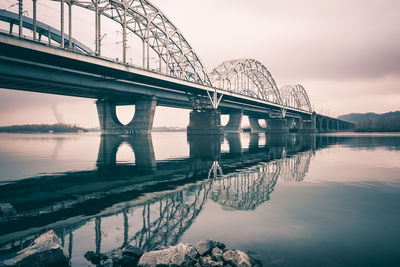 New darnytskyi bridge over dnieper river against sky