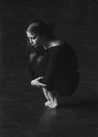 Young ballerina crouching on tiptoe at dance studio