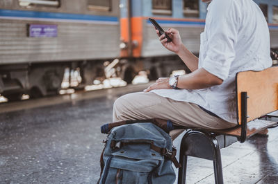 Man using mobile phone while sitting on seat