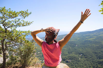 Full length of woman standing by tree against sky