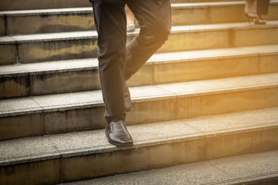 Low section of man walking on staircase