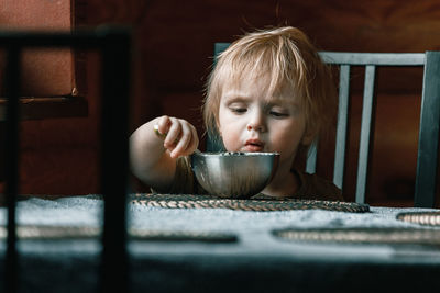 Portrait of cute baby in bowl on table