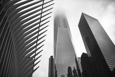 Low angle view of one world trade center amidst modern buildings against sky