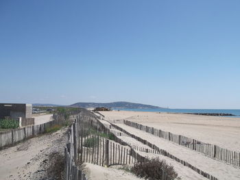 Scenic view of beach against clear blue sky