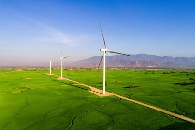 Windmill on field against sky