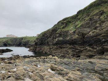 Rock formation on beach against sky