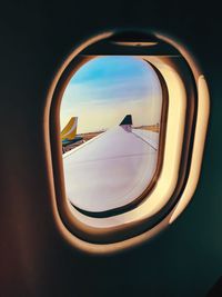 Reflection of clouds in sky seen through airplane window