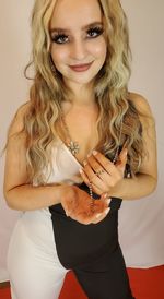 Portrait of young woman standing against wall