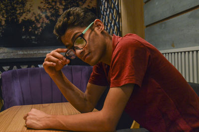 Portrait of young man sitting on table