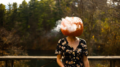 Young woman wearing a pumkin helmet with smoke coming out 