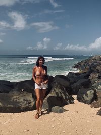 Full length of shirtless man standing on beach