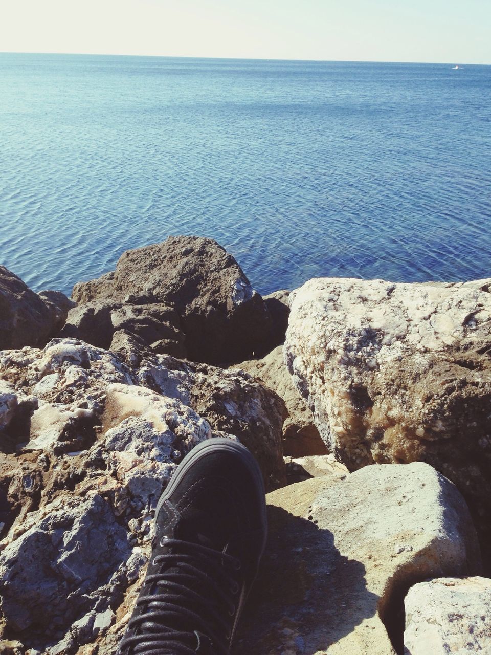 sea, water, tranquil scene, tranquility, scenics, rock - object, beauty in nature, nature, personal perspective, horizon over water, beach, high angle view, idyllic, shore, low section, sky, day, outdoors