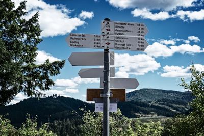 Information sign against sky