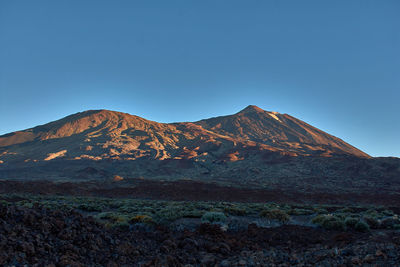 Scenic view of mountain range against clear blue sky