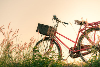 Bicycle parked on field against clear sky