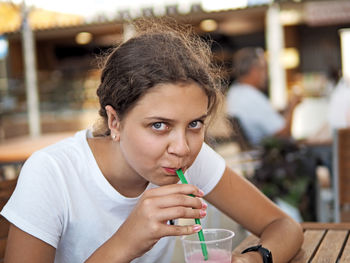 Portrait of young girl drinking glasses