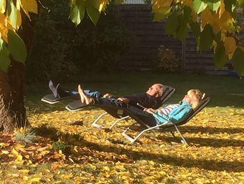 Man lying down on leaves during autumn