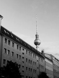 Building by fernsehturm tower against sky