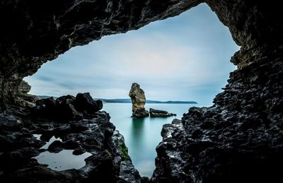 Rock formations in sea against sky