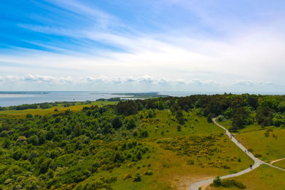 Scenic view of landscape by sea against sky