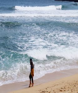 Rear view of man standing on beach