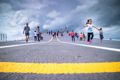 Group of people running on road