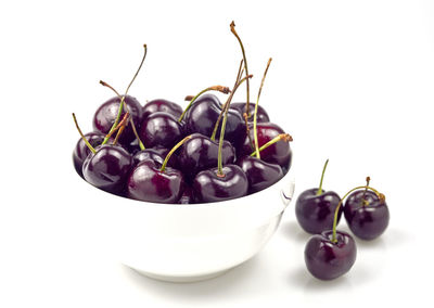 Close-up of fruits in bowl against white background