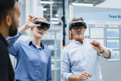 Coworkers with smart glasses having discussion at factory