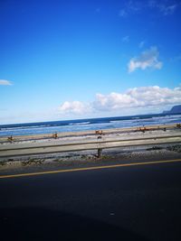 Scenic view of beach against blue sky