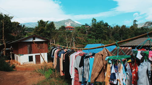Clothes drying on clothesline by building against sky
