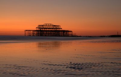 Pier over sea against sky during sunset