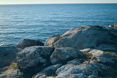 Rocks on sea shore against sky