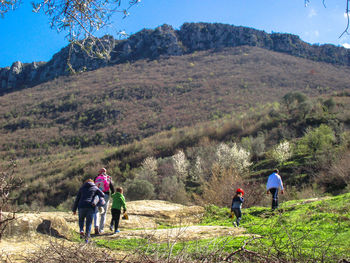 Rear view of family hiking on mountain