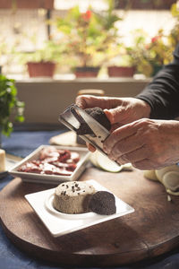 Midsection of person holding cake on table