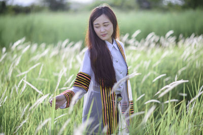 Portrait of smiling young woman standing on field