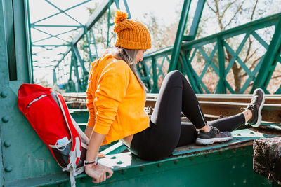 Woman trekking rests on an abandoned old railway bridge